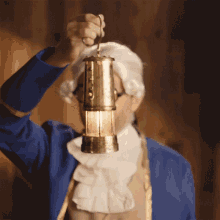 a man in a blue jacket and white wig is holding a lantern