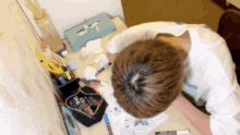a person is sitting at a desk with a box that says tissue on it
