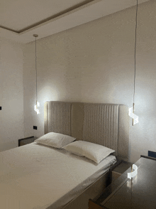 a bedroom with a bed and two pendant lights on the wall