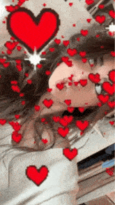 a girl is taking a selfie with red hearts flying around her face .