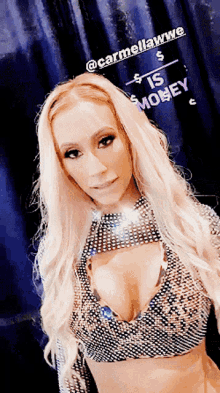 a woman in a very revealing top is standing in front of a sign that says " carmellawwe " on it