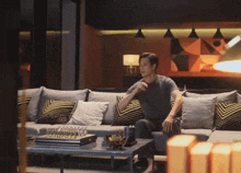 a man sits on a couch in a living room with a chess set on the table
