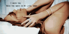 a woman is laying on a bed with the words " i need you need you back in my life baby "