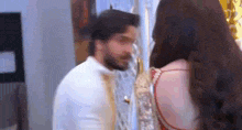 a man and woman are standing next to each other in a room .