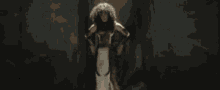 a woman with wings is standing in the dark .