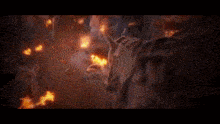 a man with a sword is standing in front of a burning building