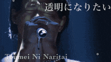 a man singing into a microphone with the words toumei ni naritai written above him