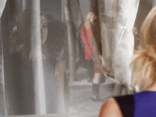 a woman looking out of a window with a reflection of herself
