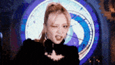 a woman is making a funny face in front of a clock .