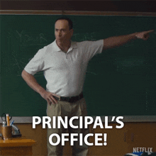 a man standing in front of a blackboard with the words principal 's office on it