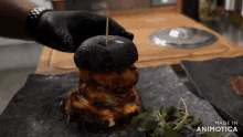 a hamburger with a toothpick in it is being made by animatica