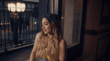 a woman in a yellow dress is looking out a window