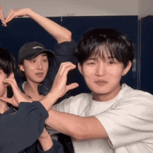 a man in a white shirt is making a heart with his hands