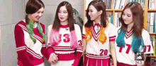 a group of young women are standing next to each other in a room .