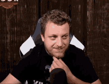 a man with a beard is sitting in front of a microphone