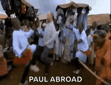 a group of people are dancing in front of a sign that says paul abroad .