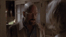 a bald man with glasses and a beard screams at a woman