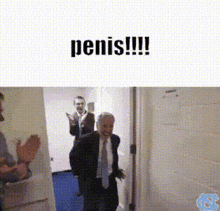 a man in a suit and tie is standing in a doorway with the words penis !!! above him .