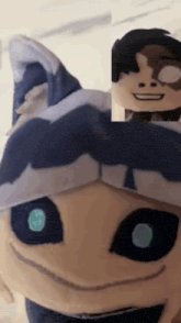 a close up of a stuffed animal with blue eyes and a hat on
