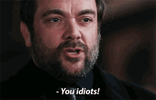 a man with a beard says " you idiots "