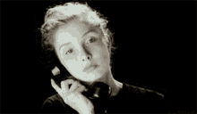 a black and white photo of a woman talking on a phone with the words ici dream below her