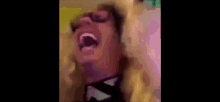 a man wearing sunglasses and a hat is screaming in a blurry video .