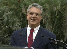 a man wearing a suit and tie is smiling