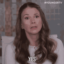 a woman in a white shirt says yes in front of a younger tv logo