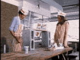 a man and a woman are standing next to each other at a table in a restaurant .