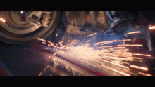 a close up of a person grinding a piece of metal with sparks coming out of it