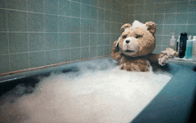 a teddy bear is taking a bath in a tub