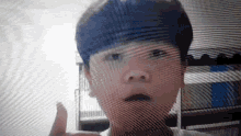 a young boy with blue hair is giving a thumbs up sign .