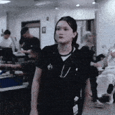 a woman with a stethoscope around her neck stands in a hospital