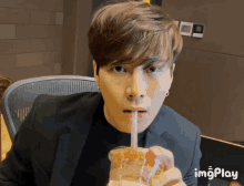 a man in a suit drinking through a straw with imgplay written in the corner