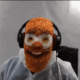 a person wearing headphones and a mask with beans on it is sitting in a chair .