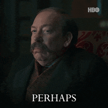 a man with a mustache is sitting in a chair with the word perhaps behind him