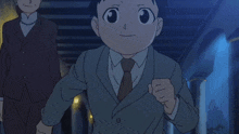 a boy in a suit and tie is running in front of a woman in a suit