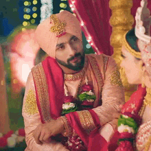 a man in a turban is sitting next to a woman in a wedding dress