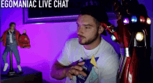 a man sitting in front of a purple wall with the words egomaniac live chat