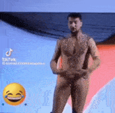 a naked man is standing on a stage with a smiley face in the background .