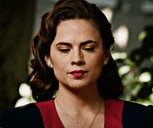 a woman wearing a necklace and earrings looks down