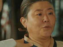 a close up of a woman 's face with a man 's hand on her neck