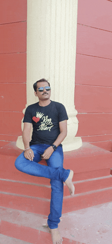 a man wearing a black t-shirt that says king of hearts