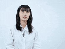 a woman in a white shirt stands in front of a pink speech bubble