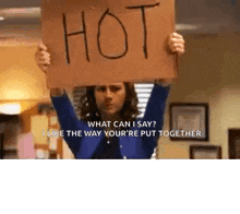 a woman is holding a sign that says `` what can i say ? i like the way your 're put together '' .