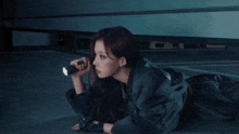 a woman is holding a flashlight in her hand in a dark room