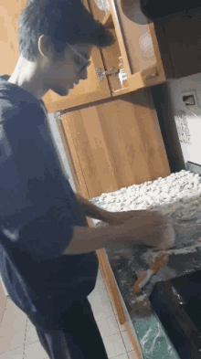 a man in a black shirt is preparing food on a countertop