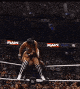 a woman is wrestling another woman in a ring with a w logo in the background .