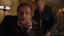two men are standing next to each other and one has a watch on