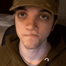 a young man wearing a hat and a hoodie with the letter c on the hood